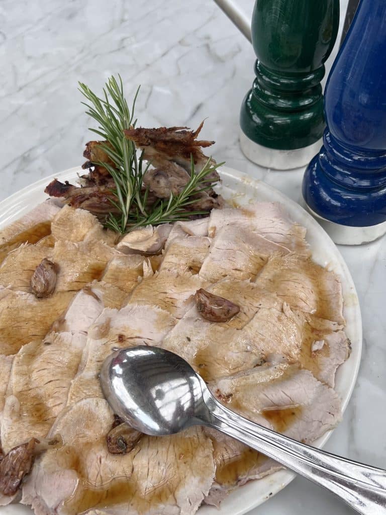 Plate of roasted pork with rosemary.