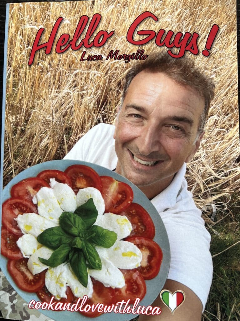 Book cover Hello Guys by Luca Morgillo. Luca holding a plate of tomatoes, mozzarella, and basil.