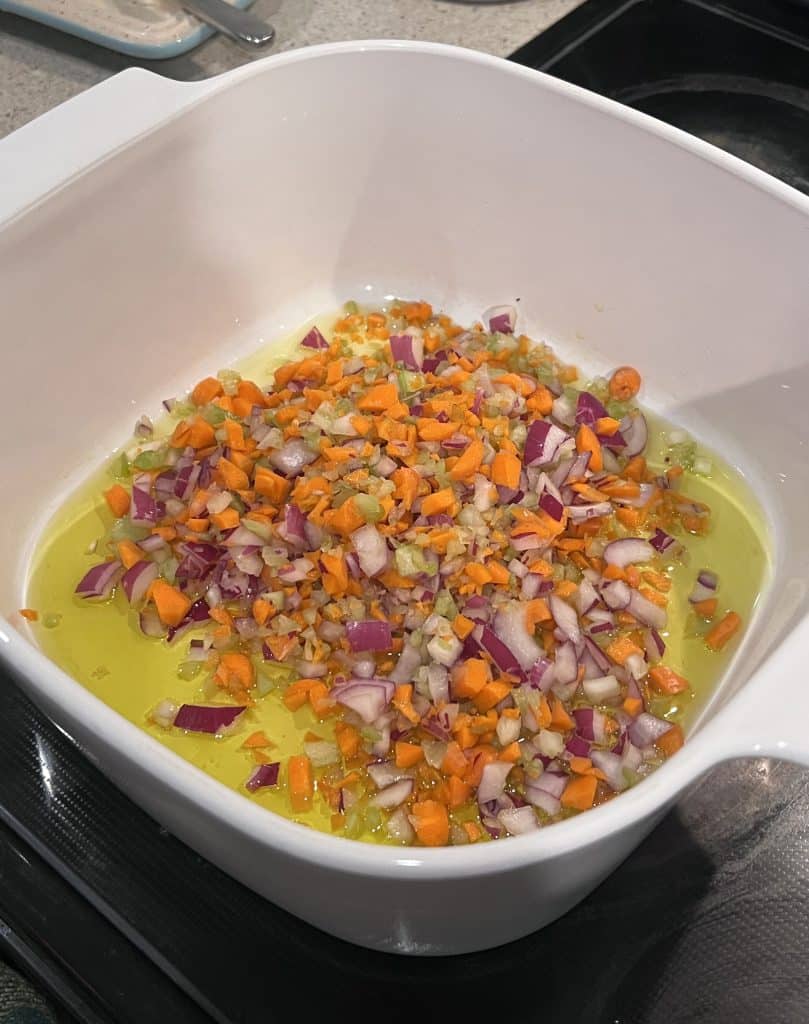 Celery, red onion, carrot mixture heating in olive oil to make the soffritto.