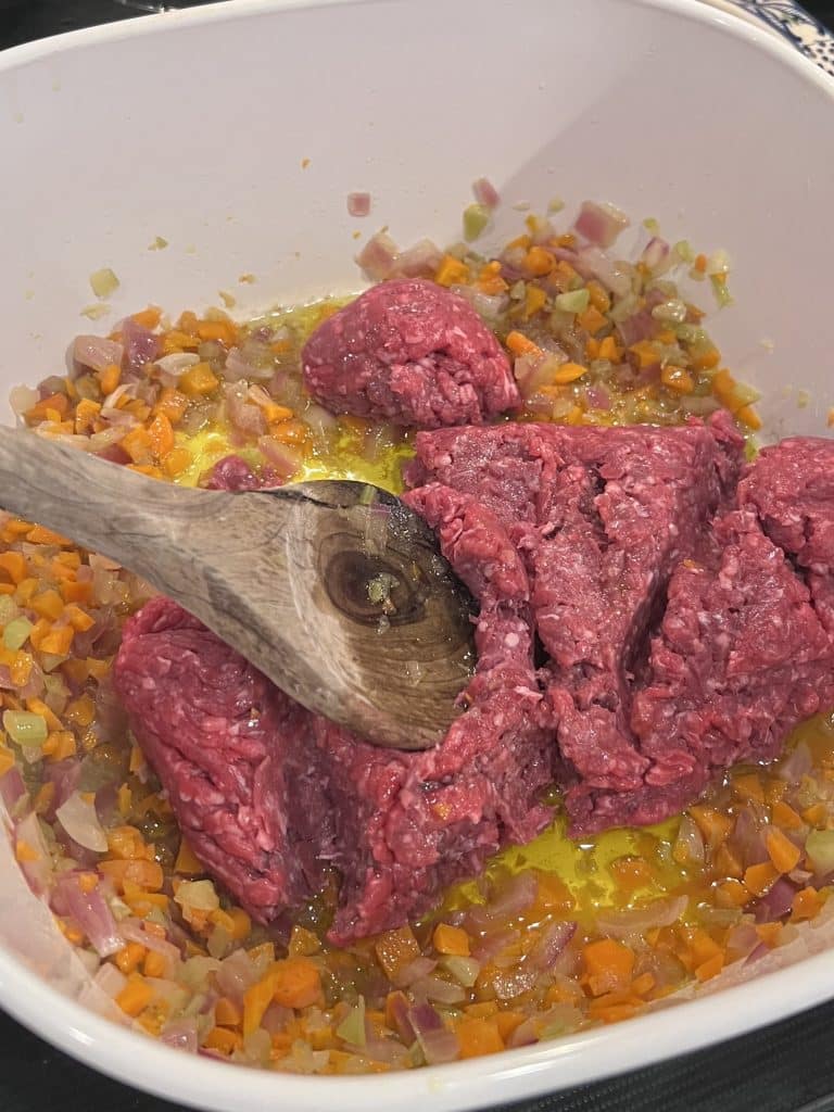 Adding ground beef to the soffritto mixture.