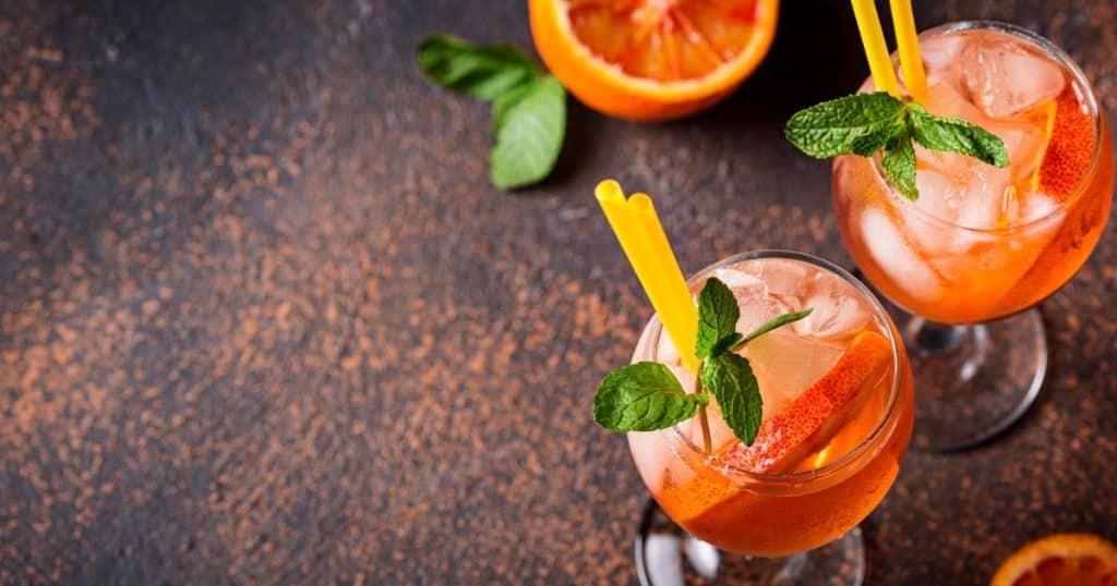 Orange Aperol spritz beverages. Ancestry trip anxiety can be helped with relaxing.