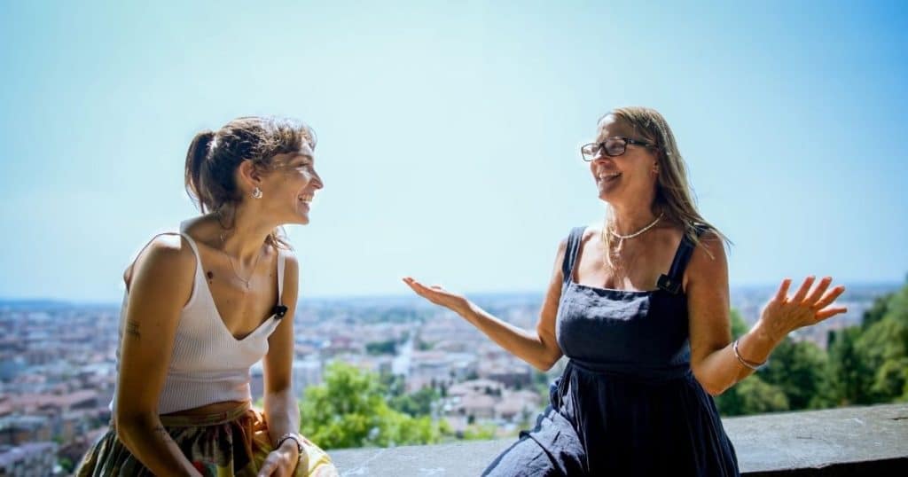 Two women on the Venetian wall overlooking Bergamo lower town during Italia Lombarda podcast interview with Justine.