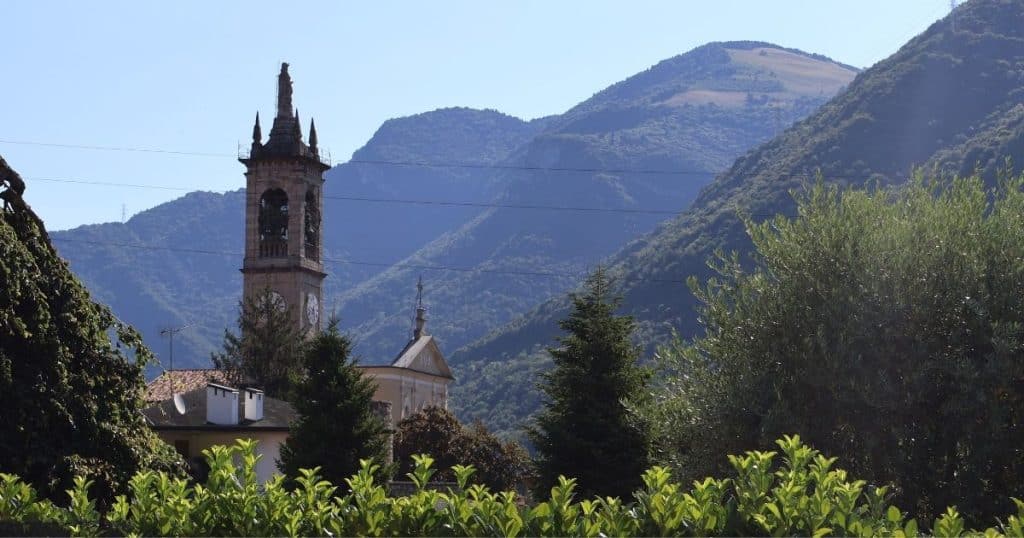 Mountains and church steeple in Casazza, BG. Ancestry tours include beautiful scenery.