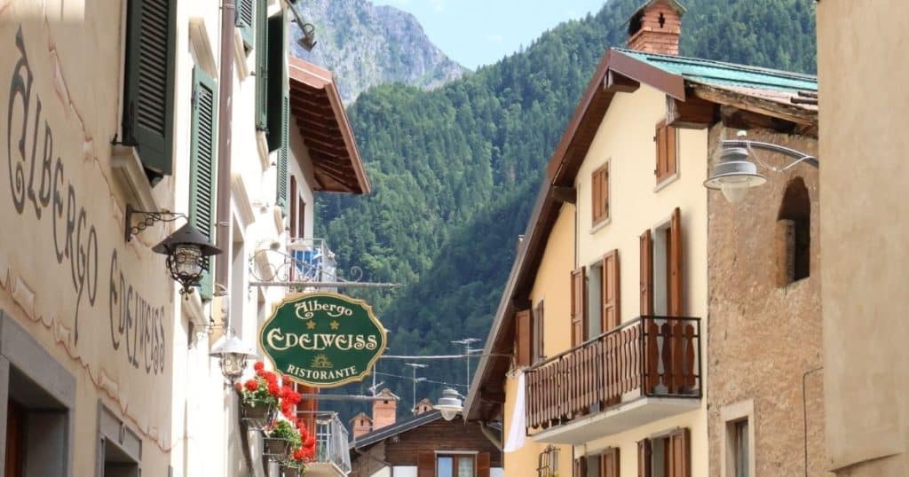 Street view in alpine village Schilpario with mountains in the background. Ancestry tours in Italy take you to tiny villages.