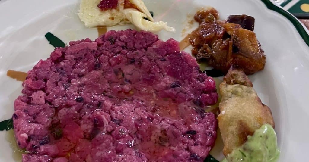 Beef tartare with eggplant caponata, fried zucchini, and cheese, plated at Il Mannarino in Milan