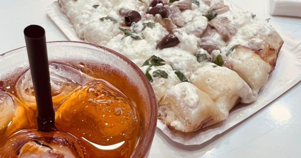 White pizza al trancio with olives and basil, served alongside a Negroni sbagliato at il Forno