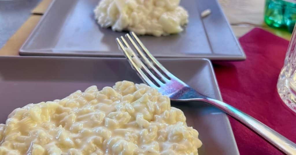Creamy Risotto Carnaroli with Taleggio and pears served on a square plate at Naviglio 48 in Milan