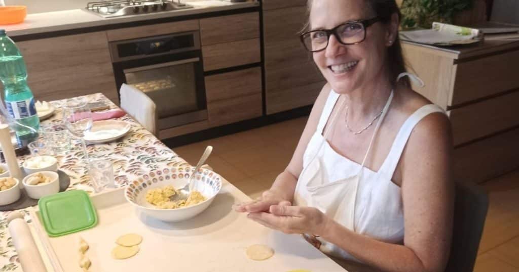 Women rolling the filling into little balls to put in the center of the pasta cricles and mini omelettes cooking in the oven.