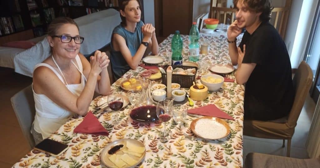 Guest sitting at the table with the host's family for the final meal of the Bergamo cooking class.