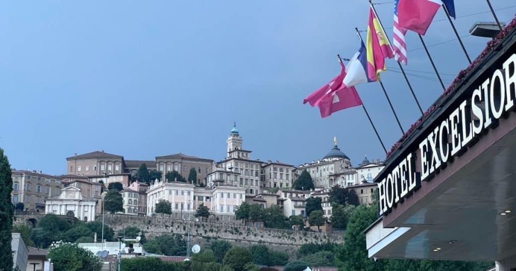Flags above the Hotel Excelsior San Marco Hotel with stunning view of Città Alta in the background was the meeting point for Bergamo Cooking Class.