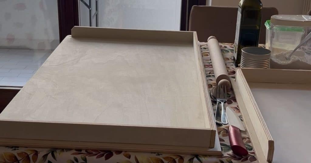 Spianatoia or pasta board, rolling pin, flour, olive oil and other tools for making homemade pasta.