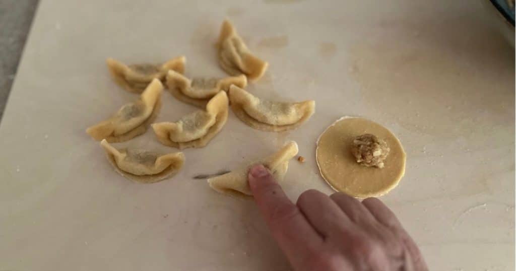 Pasta circles being filled and shaped.